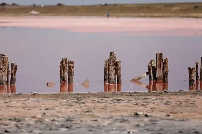 Framed Print : A fantastic pink salt lake with salt crystals on wooden pillars on sunny day Framed Print : A fantastic pink salt lake with salt crystals on wooden pillars on sunny day