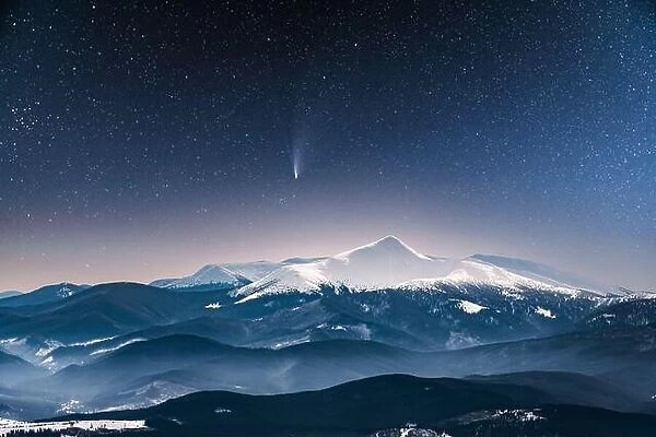 Fantastic winter landscape glowing by star light. Dramatic wintry scene with snowy trees and comet in night sky. Carpathians, Europe