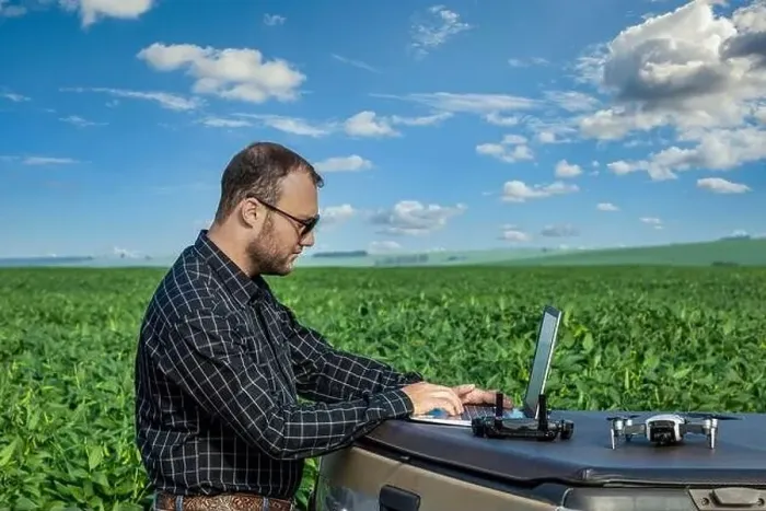 Framed Print : Farmer standing in soybean field looking at notebook and drone Framed Print : Farmer standing in soybean field looking at notebook and drone