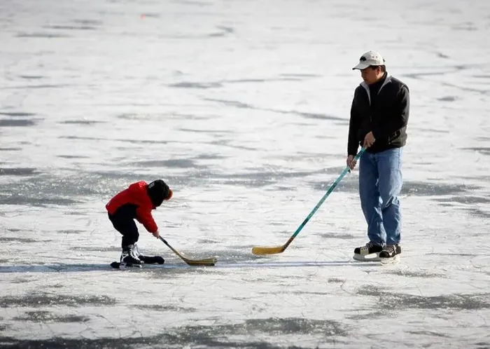 Framed Print : Father and son playing ice hockey on a frozen lake Framed Print : Father and son playing ice hockey on a frozen lake