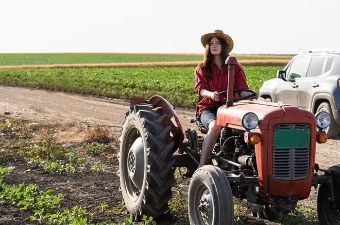 Framed Print : Female farmer driving a tractor in field Framed Print : Female farmer driving a tractor in field