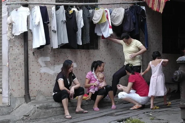 Framed Print : --FILE--Female Chinese migrant workers chat and take care of their children outside their rented houses in ChangAn town, Dongguan city, south Chinas G Framed Print : --FILE--Female Chinese migrant workers chat and take care of their children outside their rented houses in ChangAn town, Dongguan city, south Chinas G