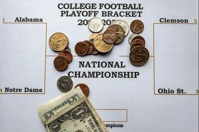 Framed Print : Filling out a sports bracket and betting money on the winner Framed Print : Filling out a sports bracket and betting money on the winner