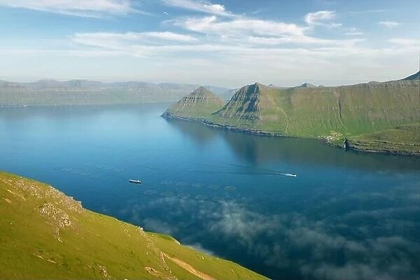Fish farm with ship on foggy fjords of Funningur, Eysturoy island, Faroe Islands. Landscape photography