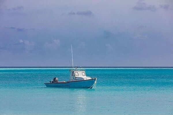 Alone fishing boat anchored in tropical lagoon, endless sea ocean horizon. Idyllic morning shore, coast view