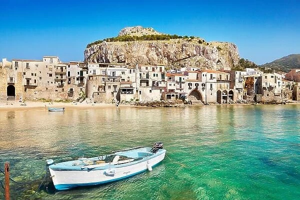 Fishing boat and medieval houses of Cefalu old town, Sicily, Italy