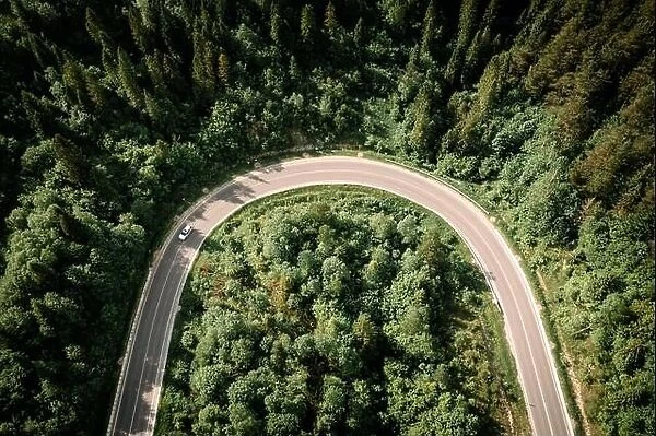 Flight over the summer mountains with mountain road serpentine and forest. Ukraine, Carpathian mountains. Landscape photography