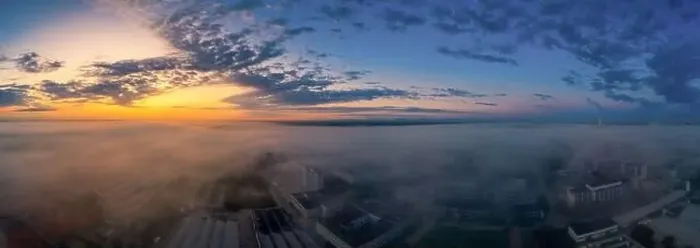 Framed Print : Foggy morning sunrise view over a business district with office buildings covered by the upcoming fog of the early