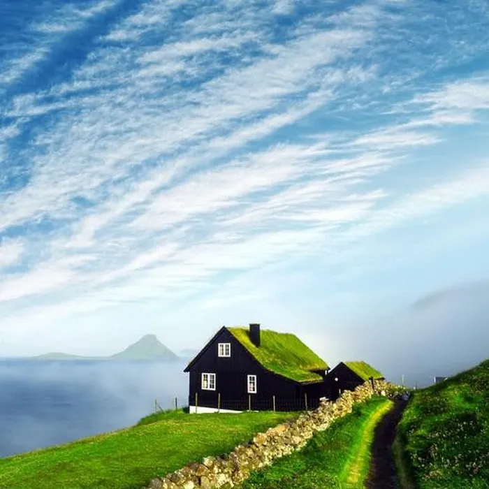 Framed Print : Foggy morning view of a house with typical turf-top grass roof and blue cloudy sky in the Velbastadur village on Streymoy island, Faroe islands Framed Print : Foggy morning view of a house with typical turf-top grass roof and blue cloudy sky in the Velbastadur village on Streymoy island, Faroe islands