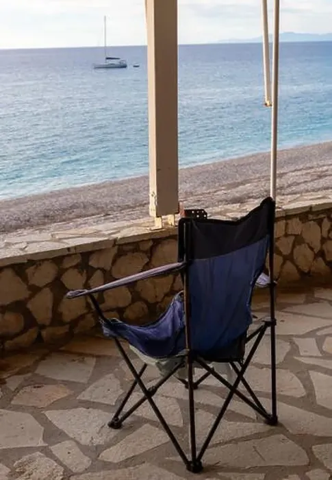 Framed Print : A folding chair on the covered patio of a seaside building with a great view of the sea and sunset sky clouds Framed Print : A folding chair on the covered patio of a seaside building with a great view of the sea and sunset sky clouds