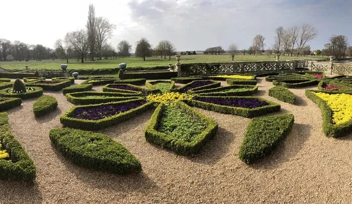 Framed Print : Formal parterre / Knot garden with spring flowers at a English county house, with parkland behind Framed Print : Formal parterre / Knot garden with spring flowers at a English county house, with parkland behind