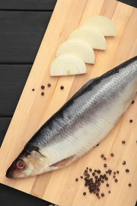 Framed Print : Fresh herring fish on cutting board on black wooden background. Top view Framed Print : Fresh herring fish on cutting board on black wooden background. Top view