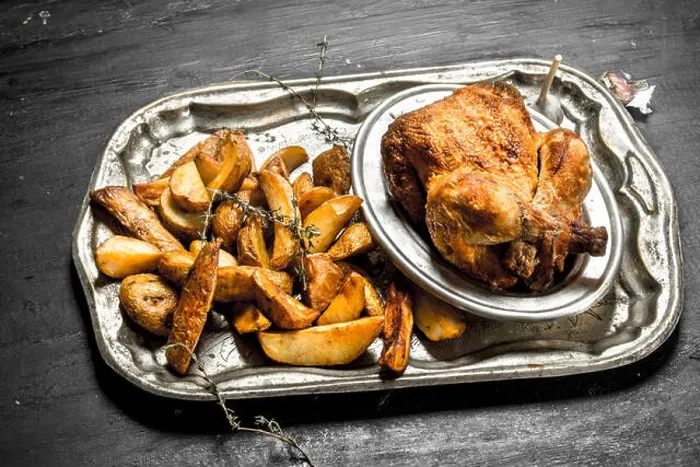Framed Print : Fried chicken with potatoes on a tray. On the black chalkboard Framed Print : Fried chicken with potatoes on a tray. On the black chalkboard