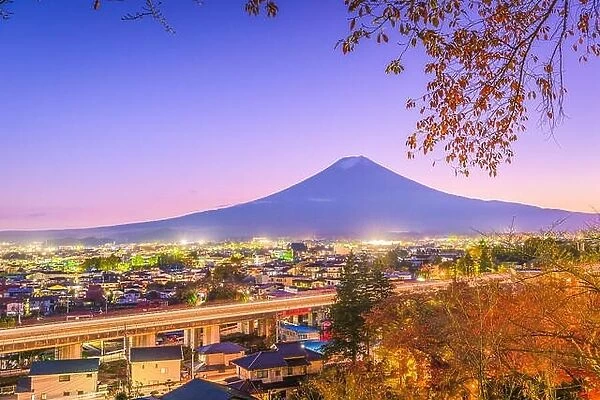 Fujiyoshida, Japan town skyline below Mt. Fuji at twilight during autumn season