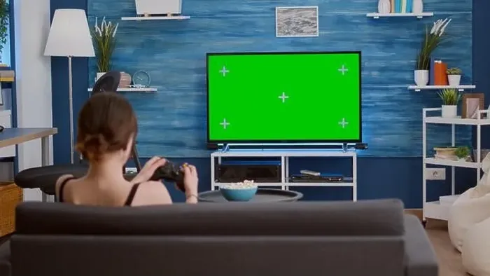 Framed Print : Gamer girl playing console video games with wireless controller on green screen tv relaxing on couch in living room Framed Print : Gamer girl playing console video games with wireless controller on green screen tv relaxing on couch in living room
