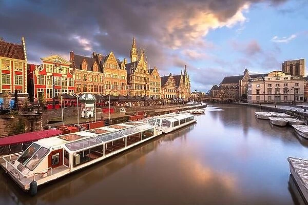 Ghent, Belgium old town cityscape and riverboats from the Graslei at twilight
