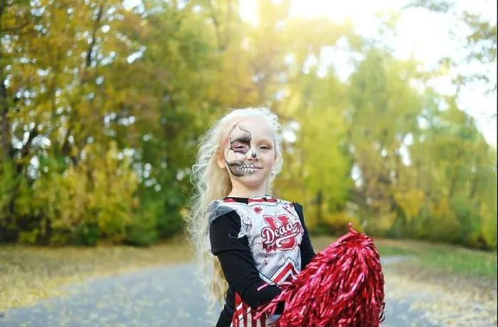 Framed Print : A girl in a cheerleader costume and half-face makeup in the form of a skeleton celebrates Halloween. Horizontal photo Framed Print : A girl in a cheerleader costume and half-face makeup in the form of a skeleton celebrates Halloween. Horizontal photo