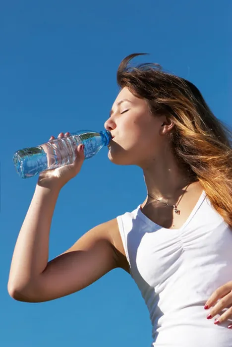 Framed Print : The girl drinking water from a bottle against the sky Framed Print : The girl drinking water from a bottle against the sky