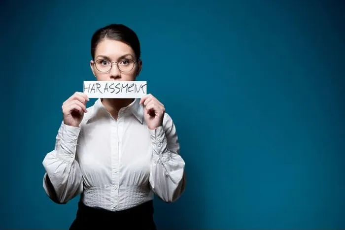 Framed Print : girl in glasses and a white shirt closes her mouth with a piece of paper with the word Harassment Framed Print : girl in glasses and a white shirt closes her mouth with a piece of paper with the word Harassment