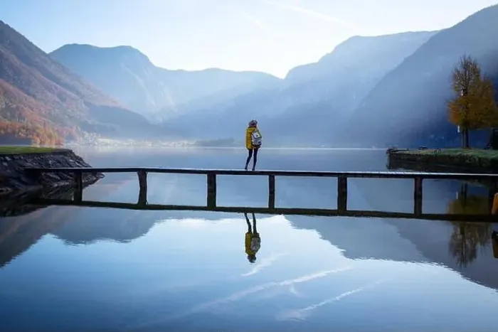 Framed Print : girl tourist in a hat and with a backpack stands on a wooden bridge on a mountain lake in the early morning Framed Print : girl tourist in a hat and with a backpack stands on a wooden bridge on a mountain lake in the early morning