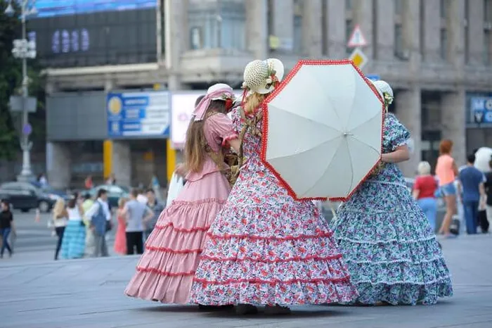 Framed Print : Three girls street vendors wearing bright vintage dresses and keeping umbrella standing on a street Framed Print : Three girls street vendors wearing bright vintage dresses and keeping umbrella standing on a street