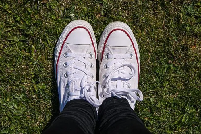 Framed Print : Girl's white Converse trainers standing on short grass looking from above Framed Print : Girl's white Converse trainers standing on short grass looking from above