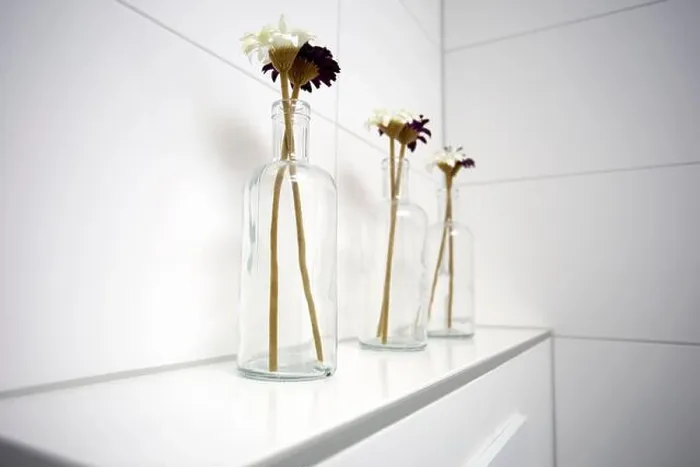 Framed Print : Three glass vases with daisies near white tiled wall in the bathroom Framed Print : Three glass vases with daisies near white tiled wall in the bathroom