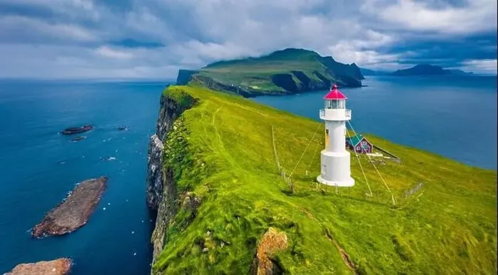 Framed Print : Gloomy view from flying drone of Mykines island with old lighthouse Framed Print : Gloomy view from flying drone of Mykines island with old lighthouse