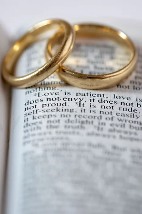 Framed Print : Two gold wedding rings lie on an open Bible. The verses are from 1 Corinthians 13 Framed Print : Two gold wedding rings lie on an open Bible. The verses are from 1 Corinthians 13