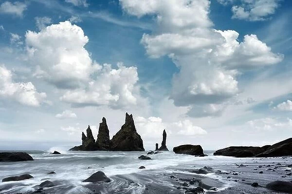 Gorgeous landscape with basalt rock formations Troll Toes on Black beach, stormy ocean waves and cloudscape. Reynisdrangar, Vik, Iceland