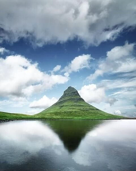 Gorgeous landscape with Kirkjufell mountain, clear lake and cloudscape in blue sky