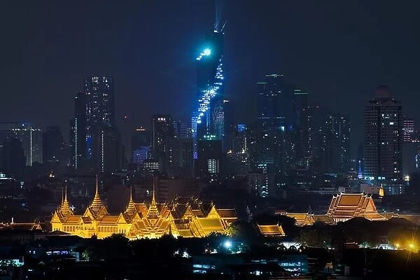 Grand palace bangkok with bangkok city skyscrapers at night in Bangkok, Thailand