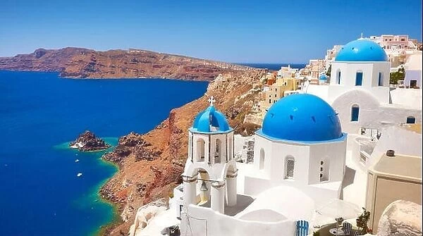 Greek white church with blue dome overlooking the Aegean sea, Oia Town, Santorini, Cyclades Islands, Greece