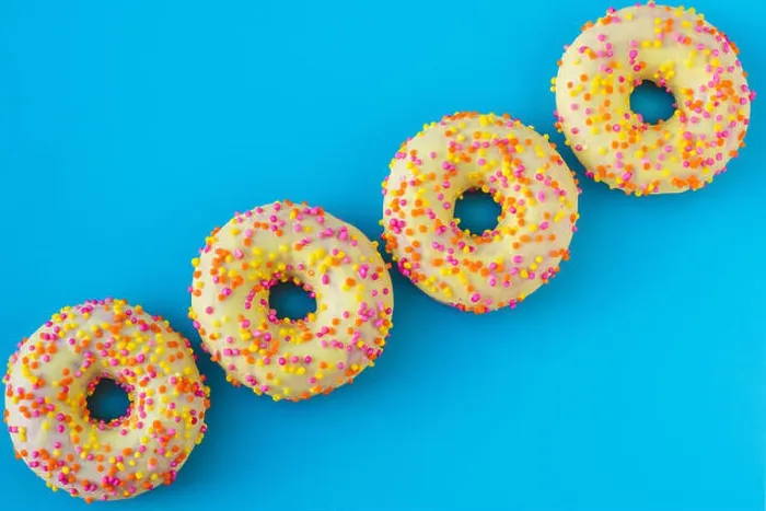 Framed Print : A group of bright motley donuts with sprinkles on blue background in abstract style Framed Print : A group of bright motley donuts with sprinkles on blue background in abstract style