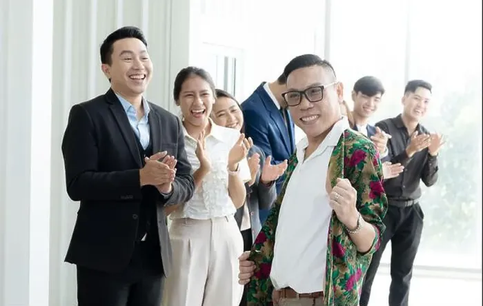 Framed Print : A group of people are smiling and clapping, with one man in a floral shirt standing out. Scene is happy and celebratory Framed Print : A group of people are smiling and clapping, with one man in a floral shirt standing out. Scene is happy and celebratory