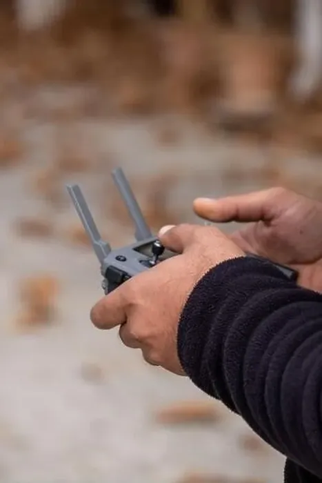 Framed Print : hand holding remote controller of flying drone Framed Print : hand holding remote controller of flying drone