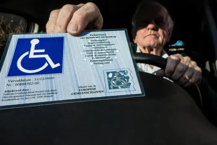 Framed Print : Handicapped elderly man placing EU parking card for people with disabilities – Blue Badge - behind windscreen of car Framed Print : Handicapped elderly man placing EU parking card for people with disabilities – Blue Badge - behind windscreen of car