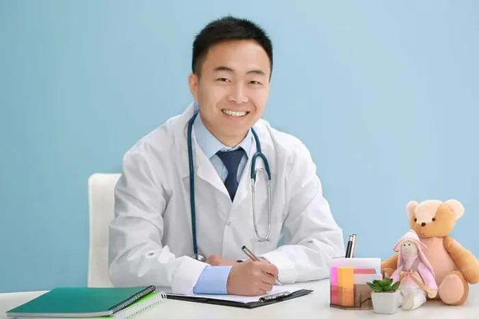 Framed Print : Handsome pediatrician doctor with teddy bear in office Framed Print : Handsome pediatrician doctor with teddy bear in office