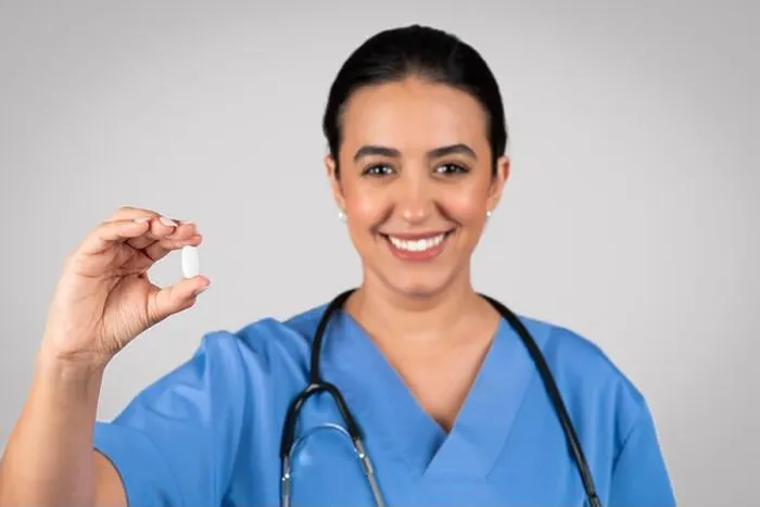 Framed Print : Happy brazilian woman doctor showing capsule pill, vitamins, food supplement in clinic on light grey studio background Framed Print : Happy brazilian woman doctor showing capsule pill, vitamins, food supplement in clinic on light grey studio background
