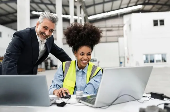Framed Print : Happy businessman with engineer having video call on laptop in factory Framed Print : Happy businessman with engineer having video call on laptop in factory