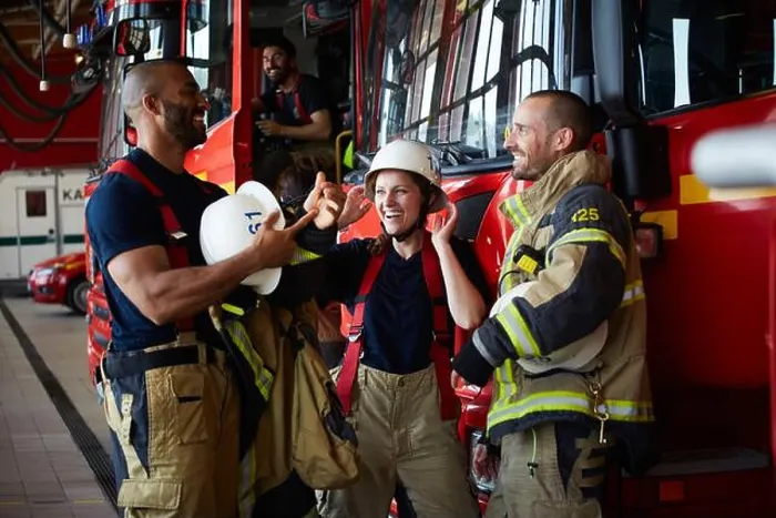 Framed Print : Happy firefighters discussing while standing by fire truck in fire station