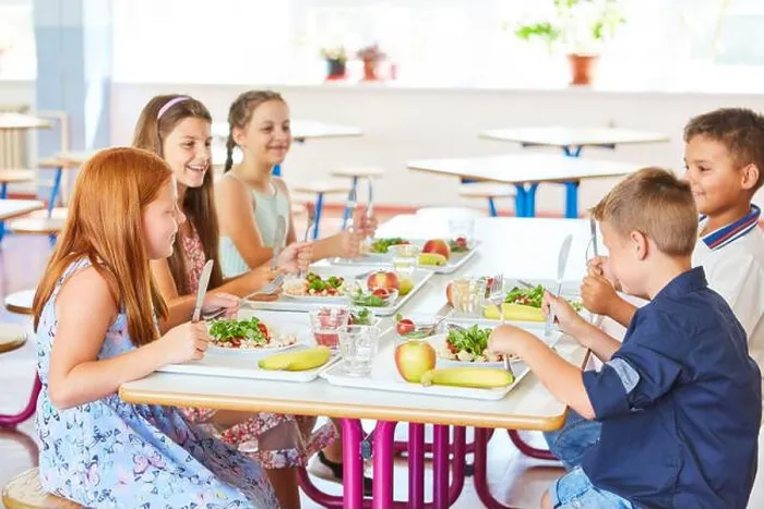 Framed Print : Happy kids having meal with cutlery while sitting together at table in school canteen Framed Print : Happy kids having meal with cutlery while sitting together at table in school canteen