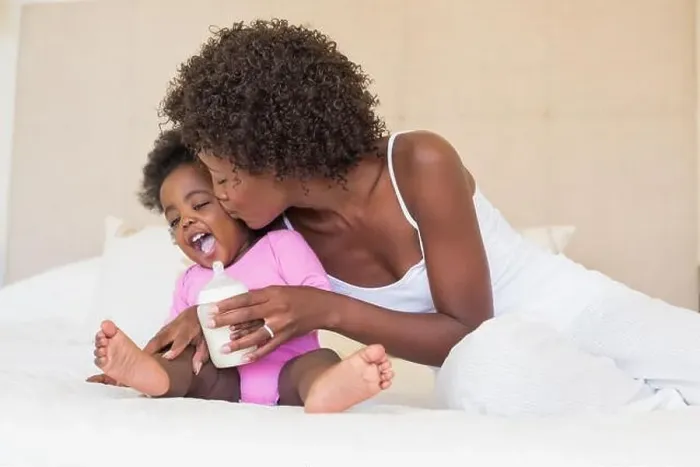 Framed Print : Happy parents with baby girl on their bed Framed Print : Happy parents with baby girl on their bed
