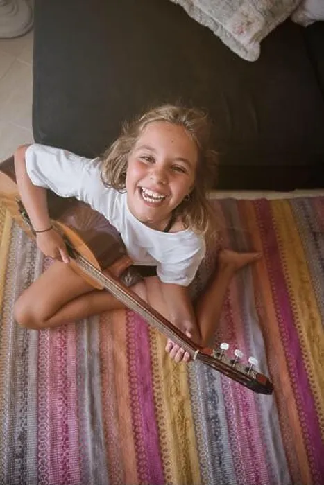 Framed Print : From above of happy preteen girl in casual clothes smiling broadly and looking at camera while sitting on carpet Framed Print : From above of happy preteen girl in casual clothes smiling broadly and looking at camera while sitting on carpet
