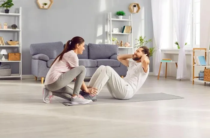 Framed Print : Happy sporty young woman helping her husband doing sport fit exercises at home Framed Print : Happy sporty young woman helping her husband doing sport fit exercises at home