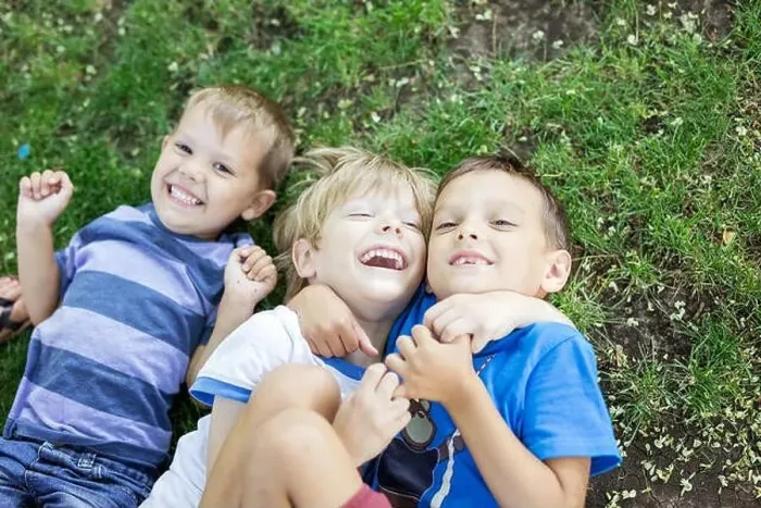 Framed Print : Three happy young boys in summer park. Friends or siblings hugging and laughing while lying down on green grass Framed Print : Three happy young boys in summer park. Friends or siblings hugging and laughing while lying down on green grass