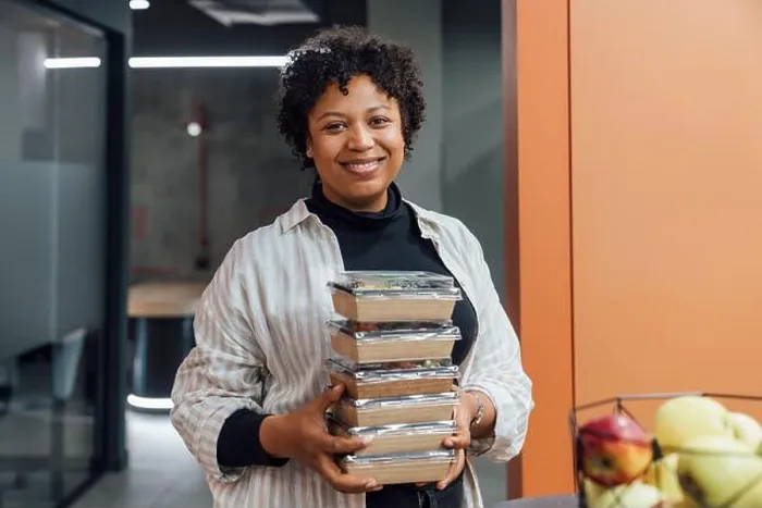 Framed Print : Happy young woman with take away food boxes standing in office