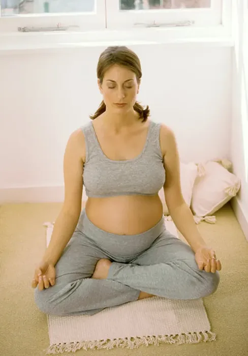 Framed Print : Heavily pregnant woman performing yoga for relaxation indoors