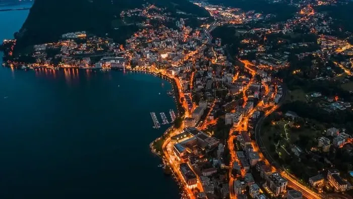 Framed Print : High angle aerial drone night shot of city street lights by lake in Lugano, Switzerland Framed Print : High angle aerial drone night shot of city street lights by lake in Lugano, Switzerland