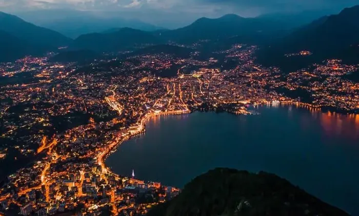 Framed Print : High angle aerial drone night shot of city street lights by lake in Lugano, Switzerland Framed Print : High angle aerial drone night shot of city street lights by lake in Lugano, Switzerland